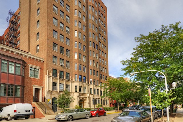 a tall brick building on the corner of a city street