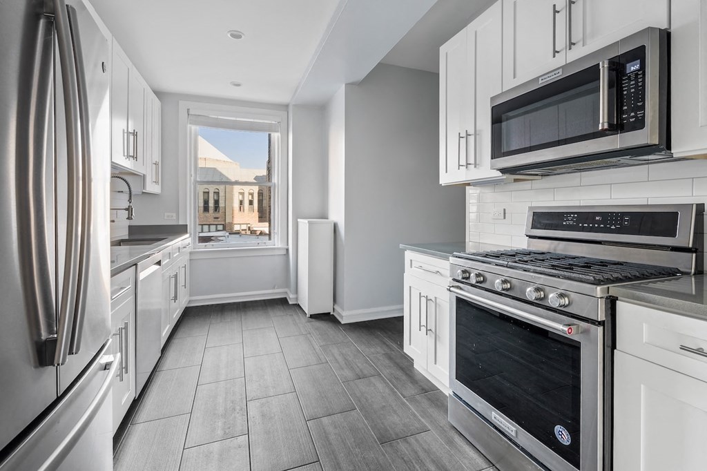 a kitchen with white cabinets and stainless steel appliances