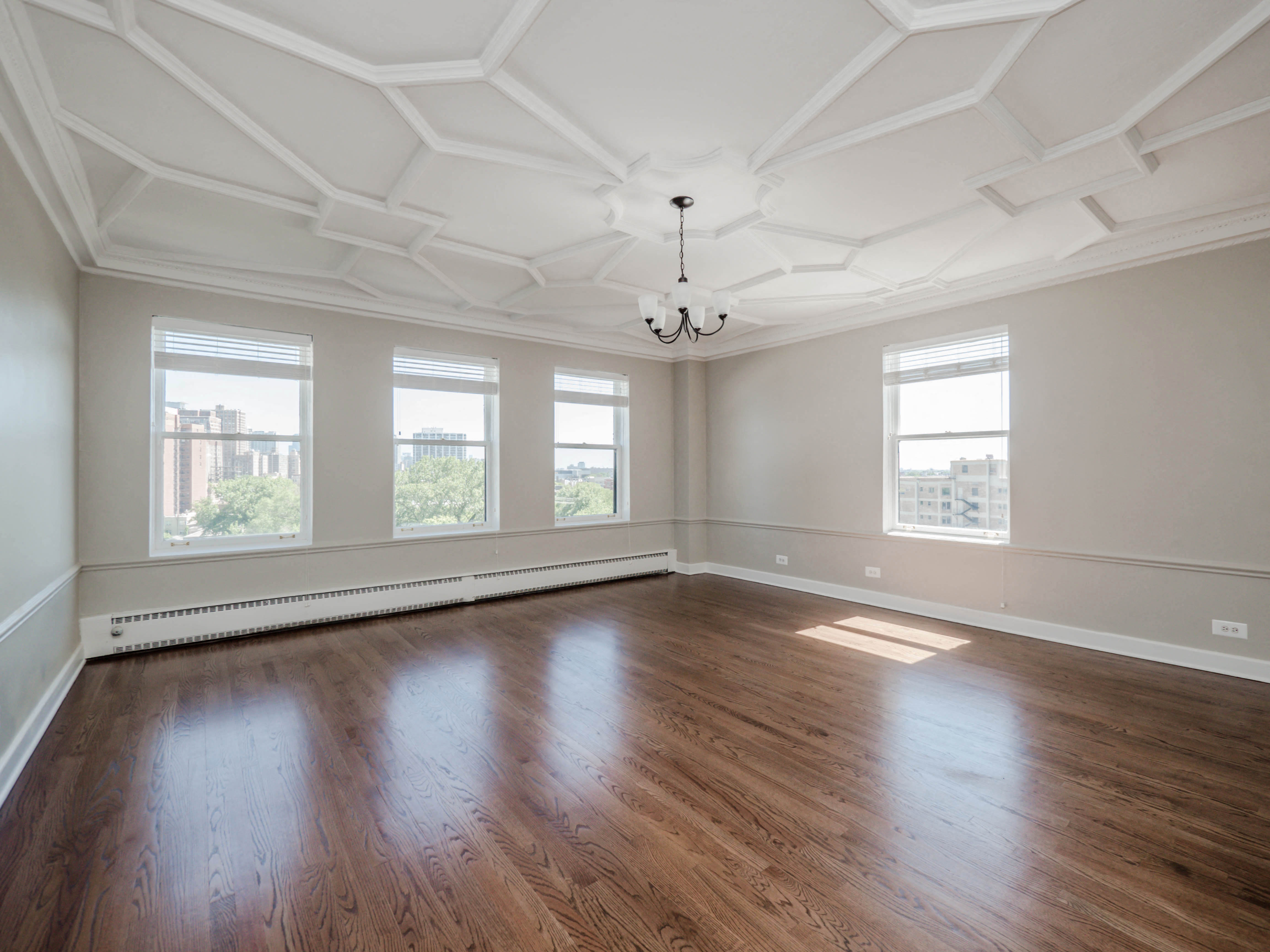 an empty living room with wood floors and windows