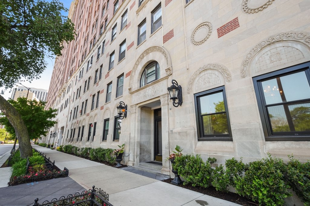the facade of a building with a sidewalk in front of it