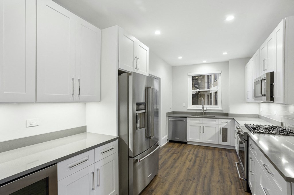a white kitchen with stainless steel appliances and white cabinets