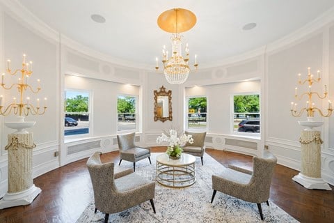 a formal living room with chairs and a table and a chandelier