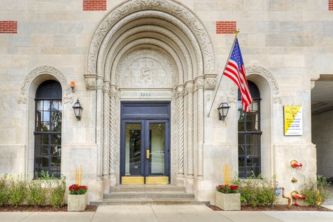 the front of a building with a door and an flag