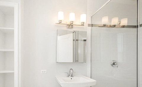 a white bathroom with a sink and a mirror