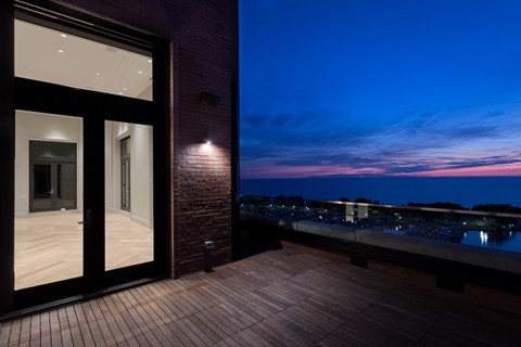 a view of the ocean from the balcony of a house at sunset