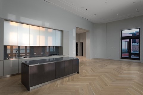 a large kitchen with white cabinets and a wooden floor