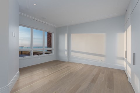 an empty living room with white walls and a window