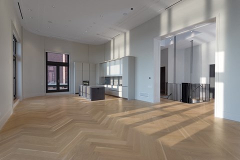 a large living room with a wooden floor and a glass door
