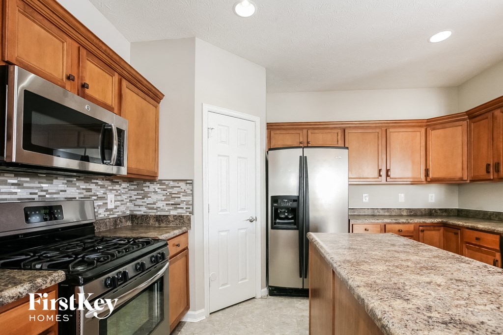 A kitchen with wooden cabinets and a granite countertop.