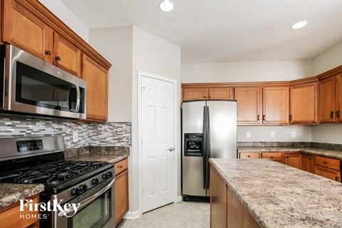 A kitchen with wooden cabinets and a granite countertop.