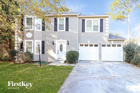 a white house with a white garage door and a lawn