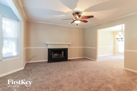 a living room with a fireplace and a ceiling fan