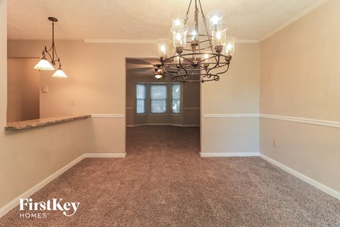 a dining room with carpet and a chandelier