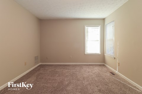 a bedroom with a carpeted floor and a window