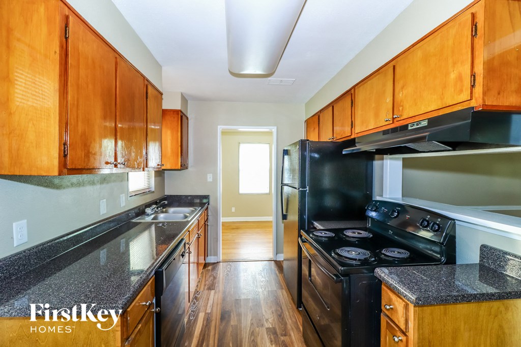 A kitchen with wooden cabinets and black appliances.