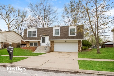 a brick house with a white garage door and a driveway