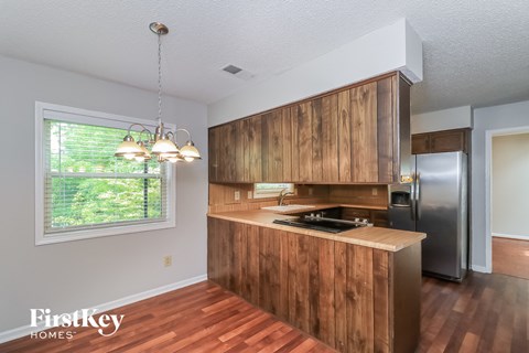 A kitchen with wooden cabinets and a stainless steel refrigerator.