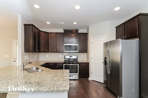 A kitchen with a granite countertop and stainless steel appliances.