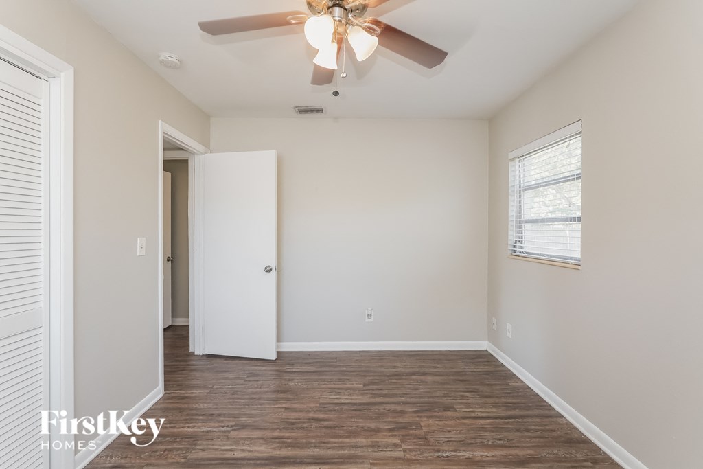 a bedroom with a ceiling fan and a door to a closet