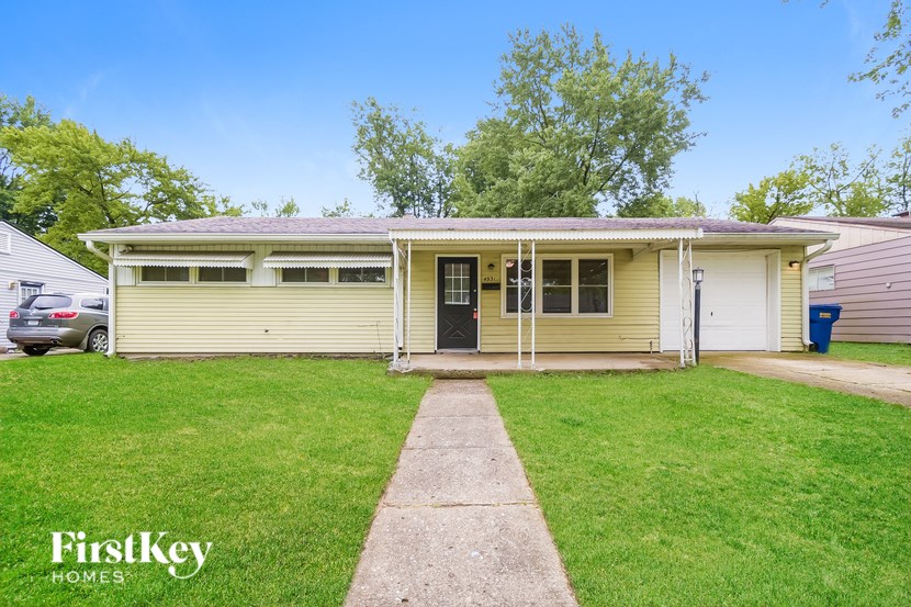 A two-story house with a garage and a driveway.