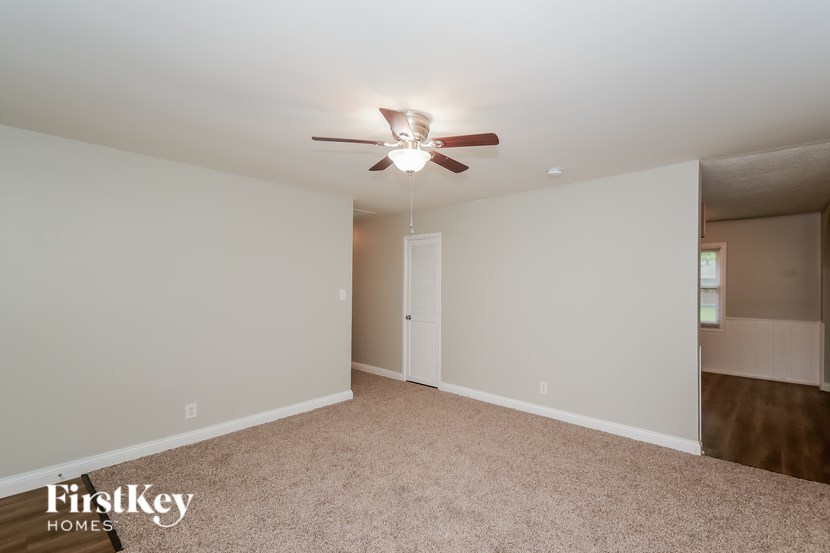 A room with a ceiling fan and a carpeted floor.
