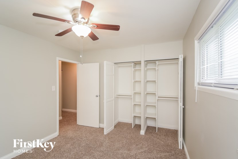 A room with a ceiling fan and a carpeted floor.
