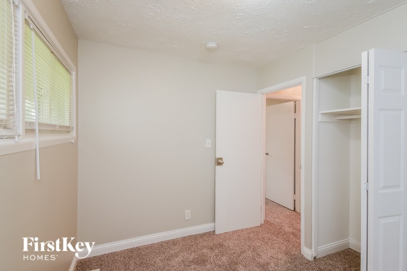 A room with a carpeted floor and a white door.