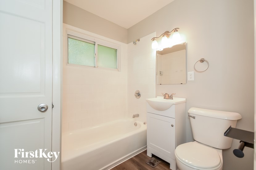 A white bathroom with a toilet, sink, and bathtub.