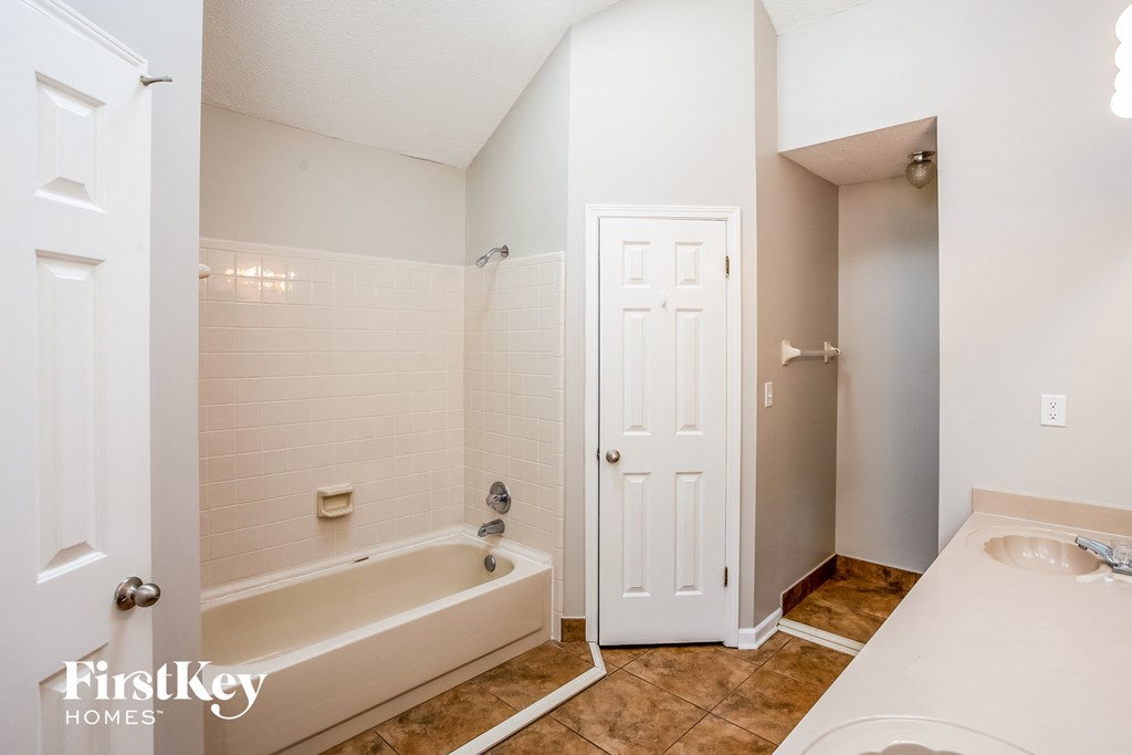 a bathroom with a tub and a sink and a door