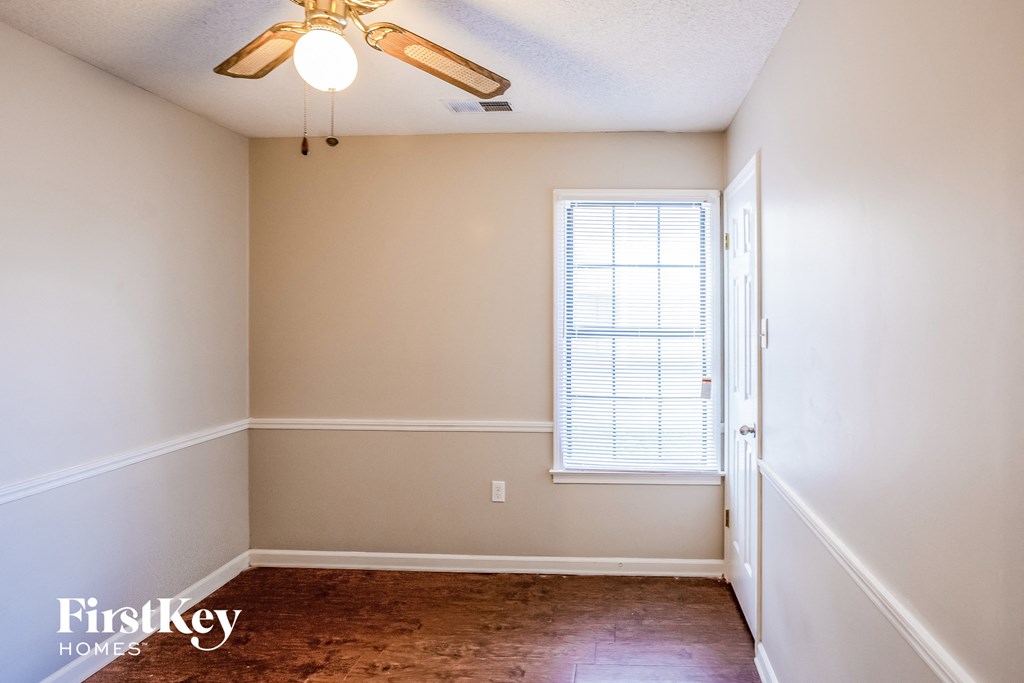 a empty room with a ceiling fan and a window