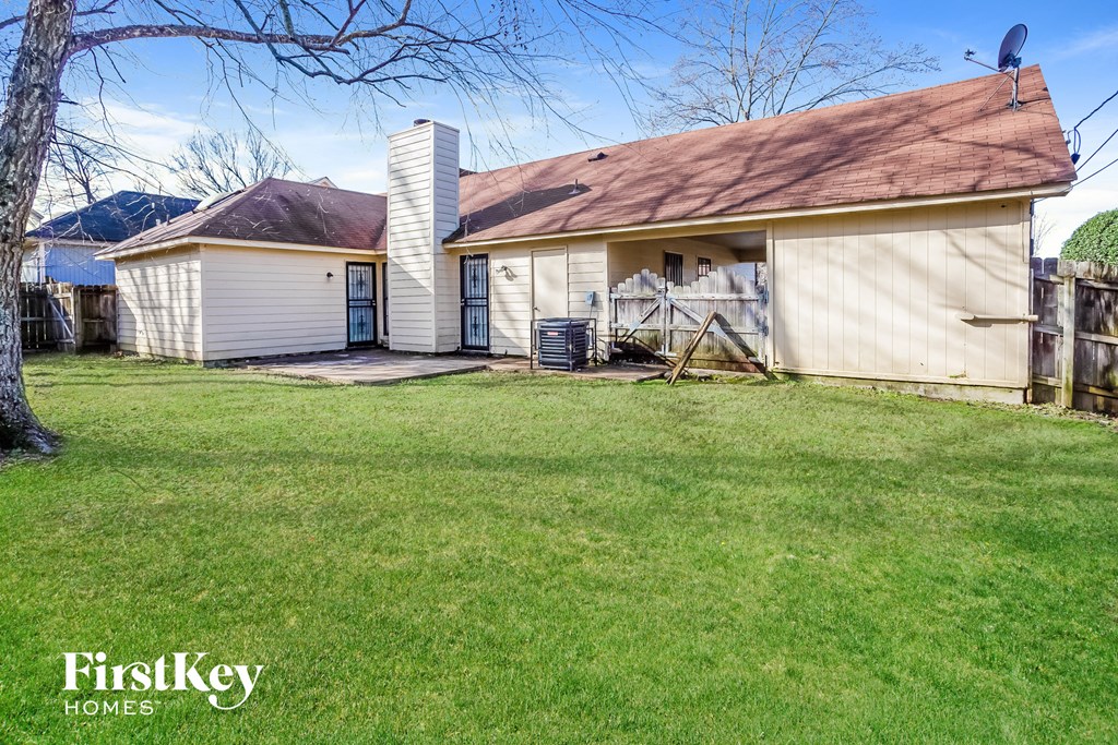 a small white house with a yard in front of it