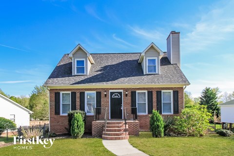 a brick house with a black door and white windows