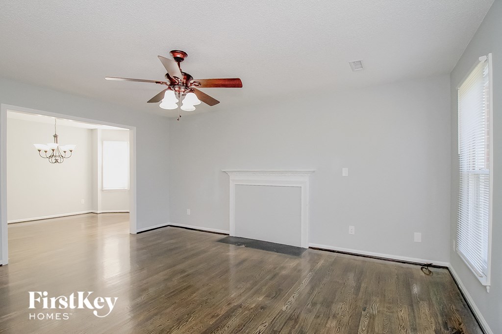 the living room and dining room with wood flooring and a ceiling fan