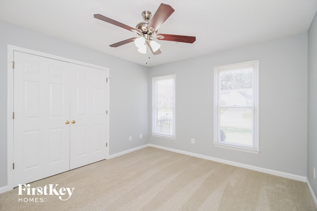 a bedroom with a ceiling fan and a closet