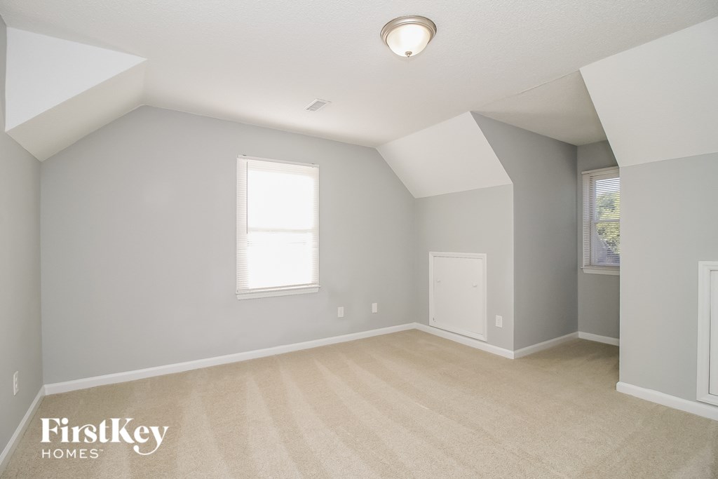 a white room with a white carpet and a window