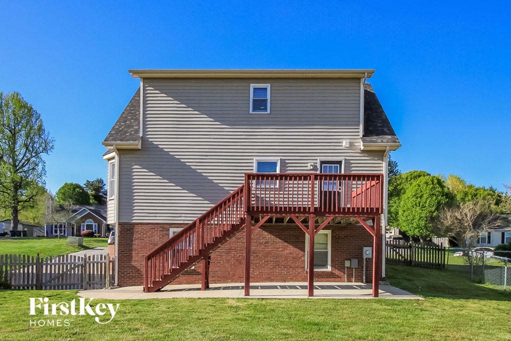 a brick house with a red porch and a wooden deck