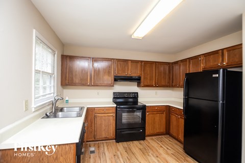 A kitchen with wooden cabinets and black appliances.