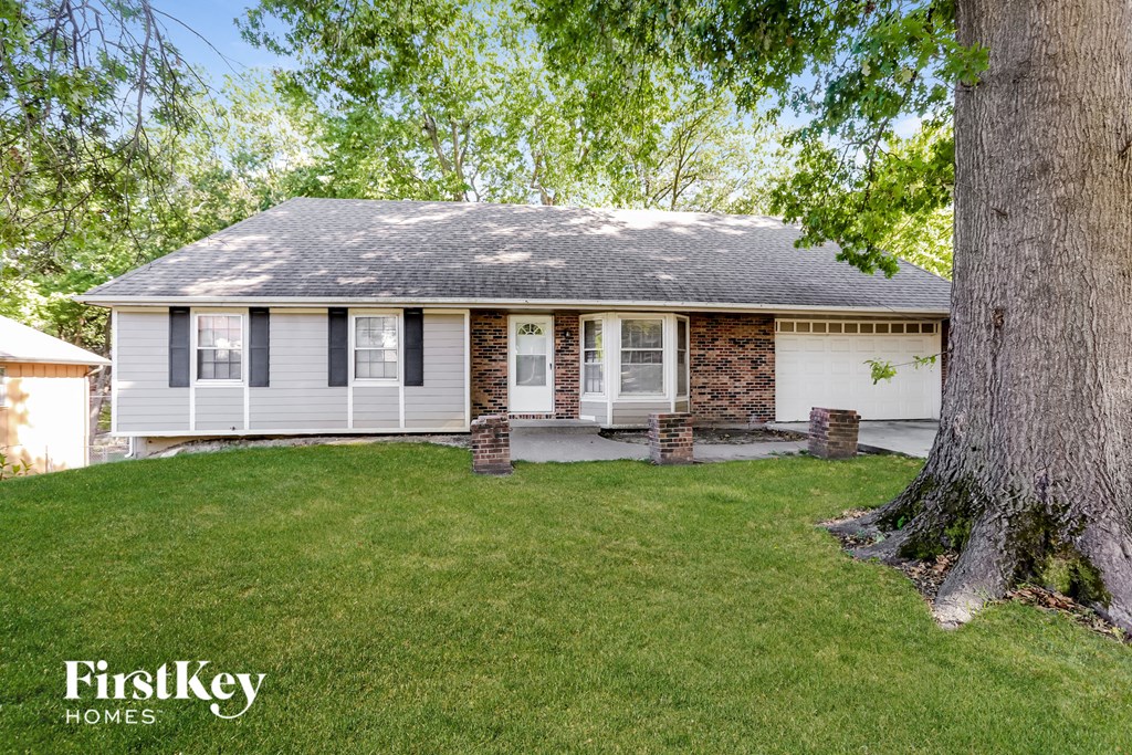 a small white house with a tree in front of it