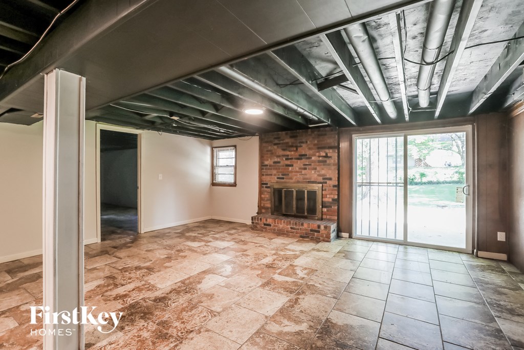 an empty living room with a fireplace and a sliding glass door