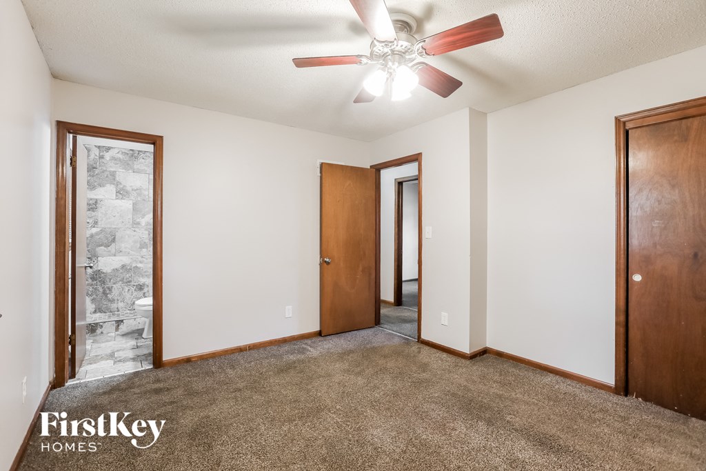 the master bedroom is spacious with a ceiling fan and carpeted flooring