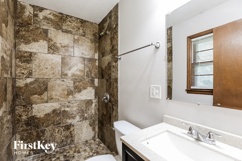 a bathroom with a shower and a sink and a toilet