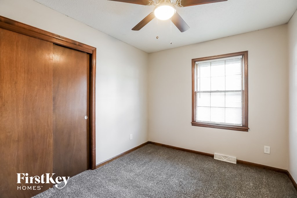the master bedroom is spacious with a ceiling fan and a closet