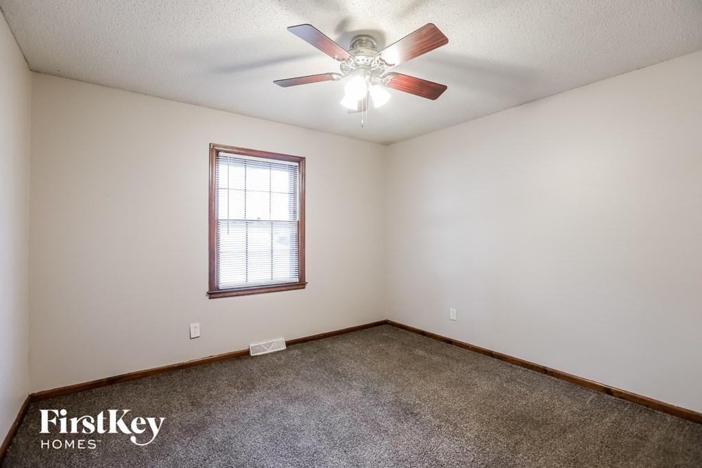the master bedroom has a ceiling fan and a carpet