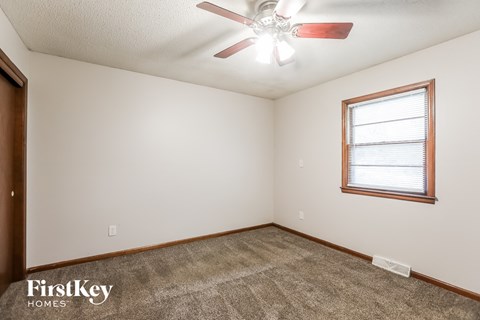 a living room with carpet and a ceiling fan