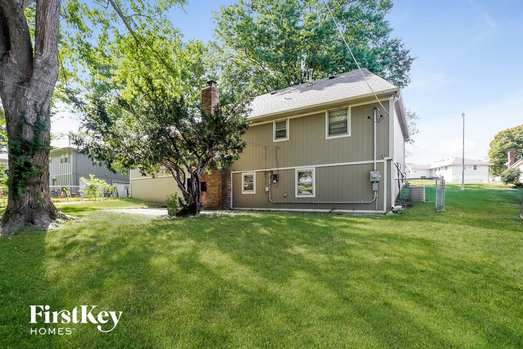 a home with a lawn and a tree in front of it
