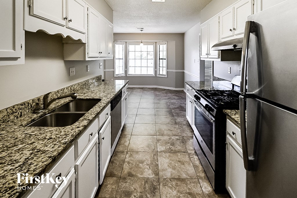 A kitchen with granite countertops and stainless steel appliances.