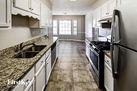 A kitchen with granite countertops and stainless steel appliances.