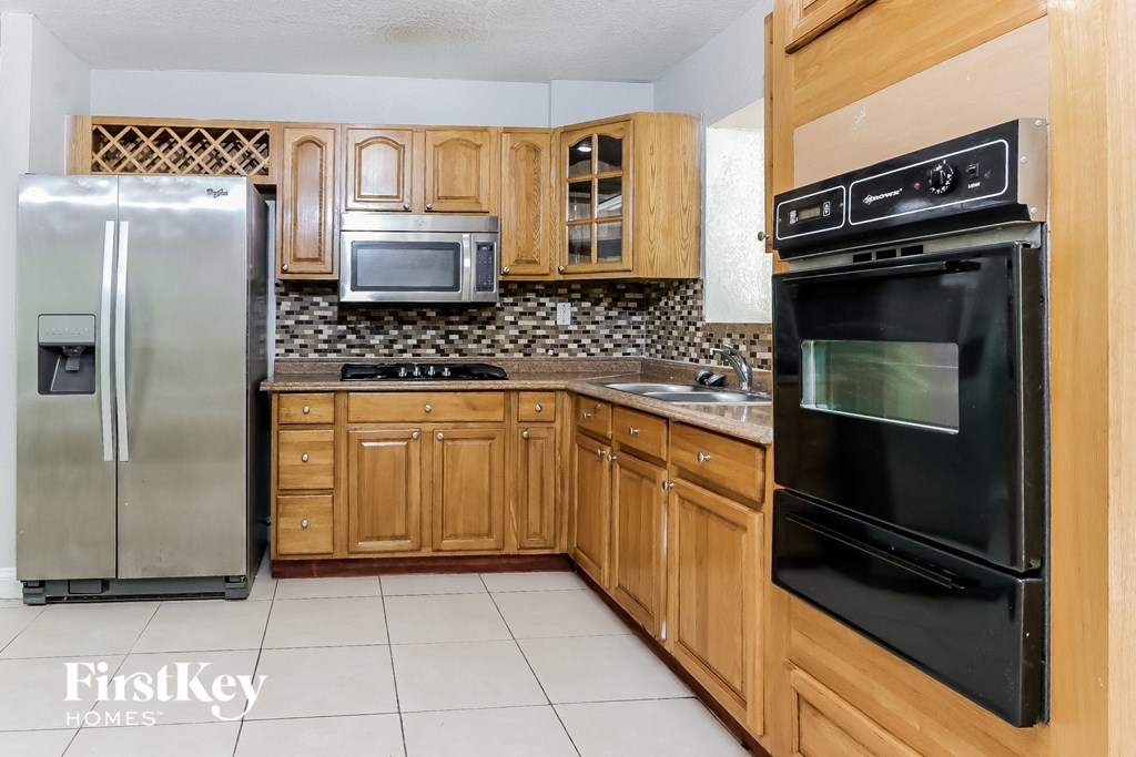 a kitchen with black appliances and wooden cabinets