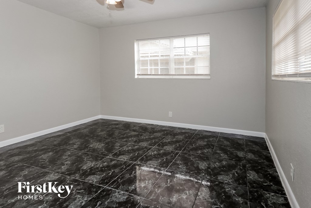 a empty room with black marble flooring and a window