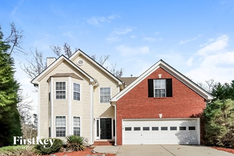 A two-story house with a red brick chimney and a white garage door.